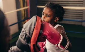 Boxing kid practicing punches on a punching pad